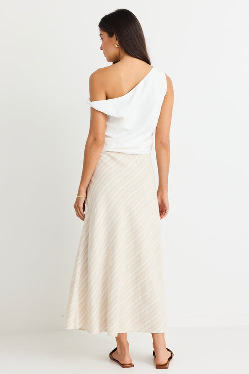 model wears linen one shoulder white top and beige midi skirt