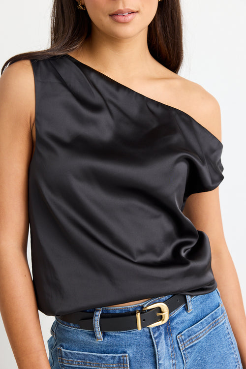 model wears a black satin one shoulder top