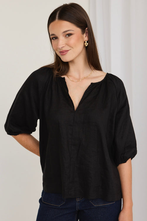 model wears a black linen shirt