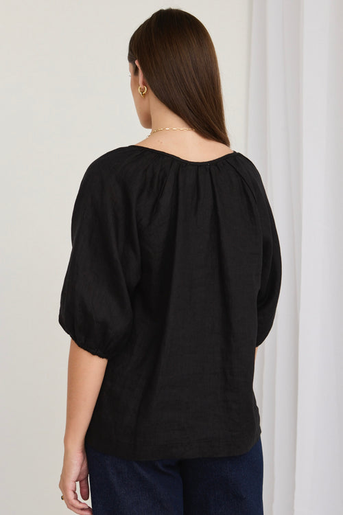 model wears a black linen shirt