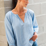 model wears a blue linen shirt