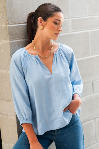 model wears a blue linen shirt