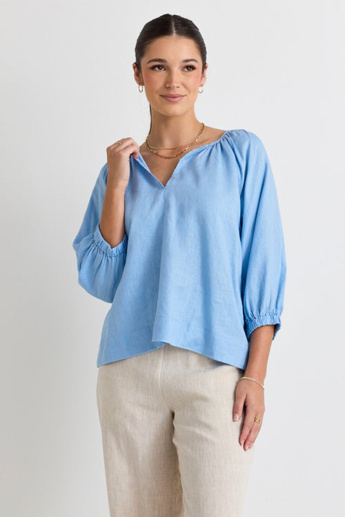 model wears a blue linen blouse