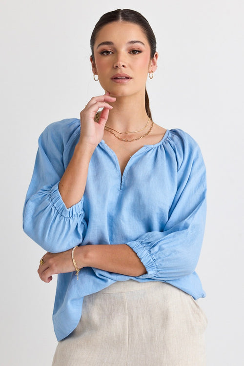 model wears a blue linen blouse