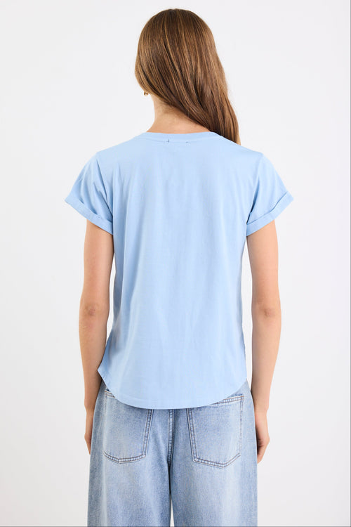Person wearing a light blue t-shirt and light blue jeans on a white background