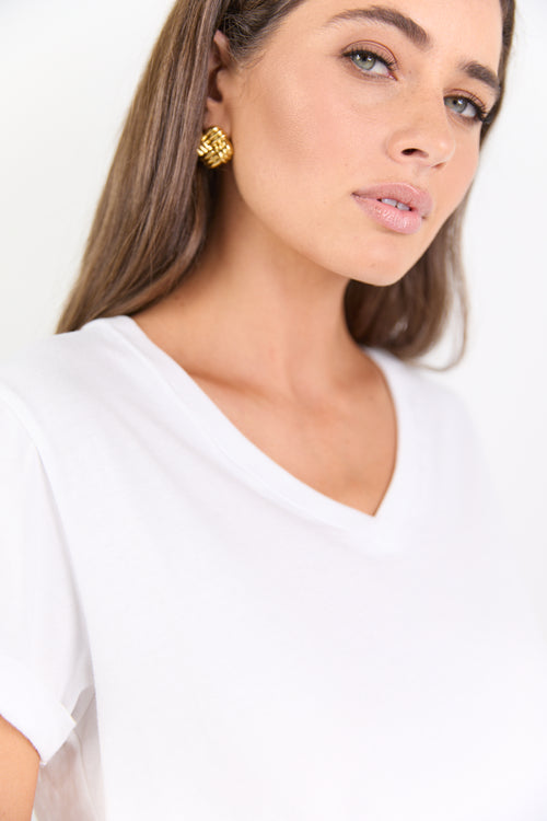 Woman wearing a white top with a plain background