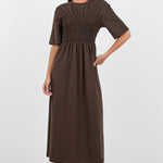 Woman wearing a brown dress on a white background