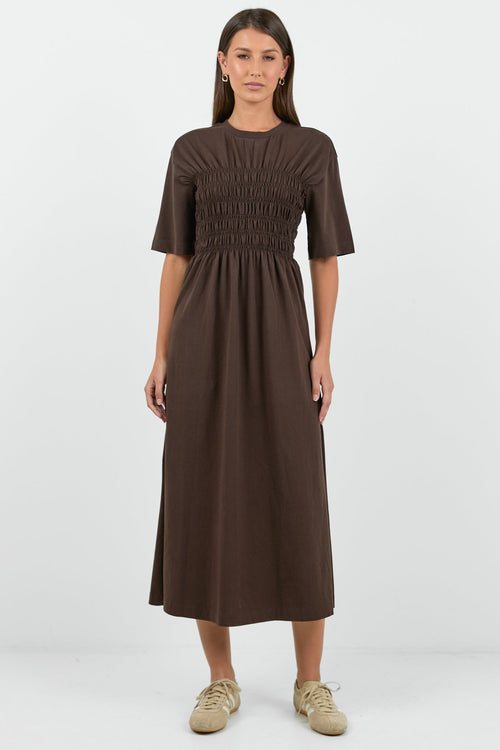 Woman wearing a brown dress on a white background