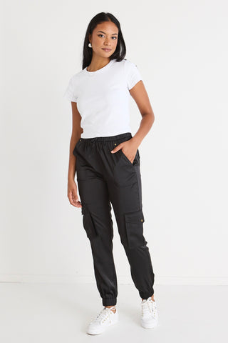model wears black cargo joggers with a white tee