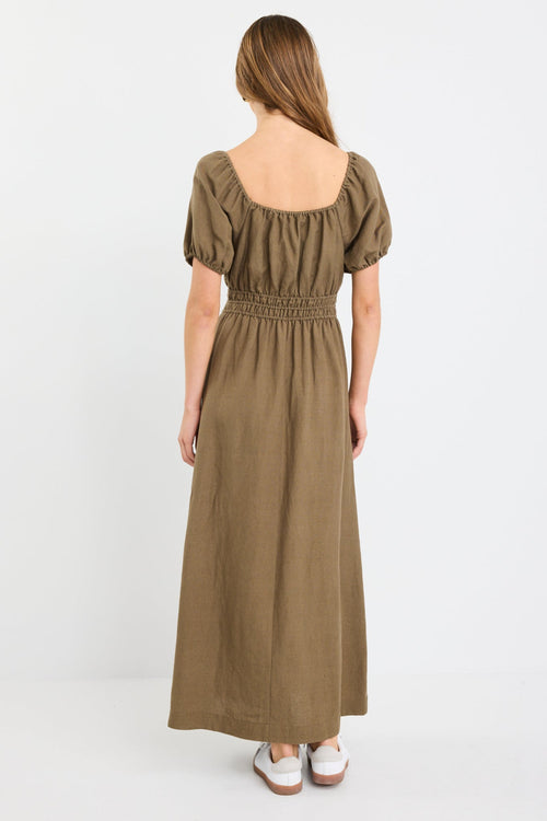 Woman wearing a khaki short sleeve linen blend midi dress with a shirred waist, tie neckline, and side split, styled with white sneakers.