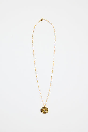 gold-plated necklace with fine chain and a round sunburst pendant featuring a central gem detail,