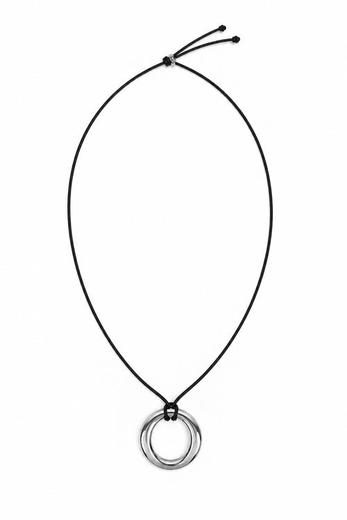 A minimalist black cord necklace featuring a double-ring pendant in polished silver-tone metal, displayed against a solid white background.