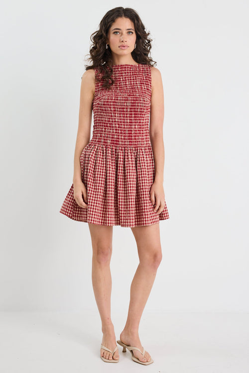 Woman wearing a red checkered dress on a white background