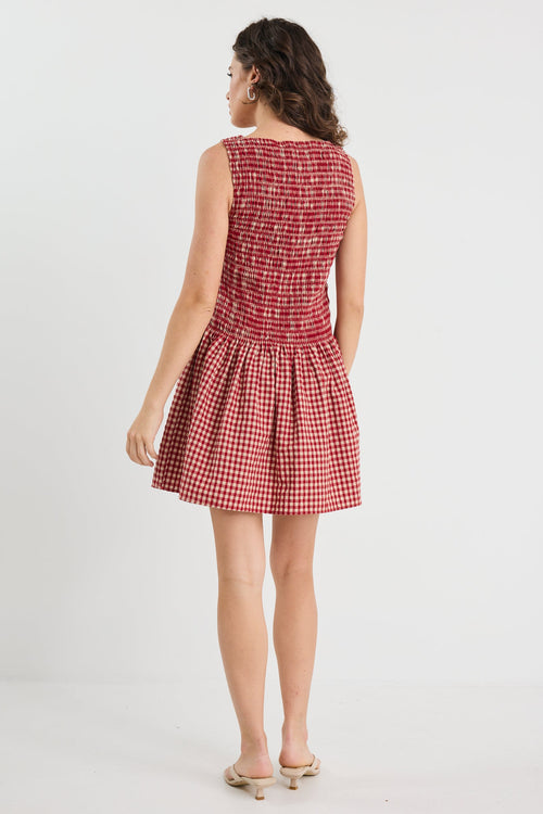 Woman wearing a red checkered dress on a white background