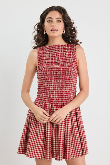 Woman wearing a red and white checkered dress on a white background