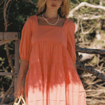 model wears a orange mini dress