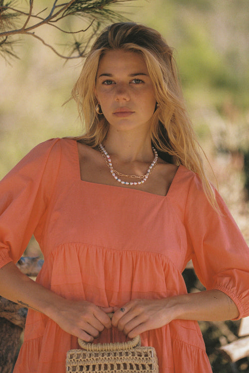 model wears a orange mini dress