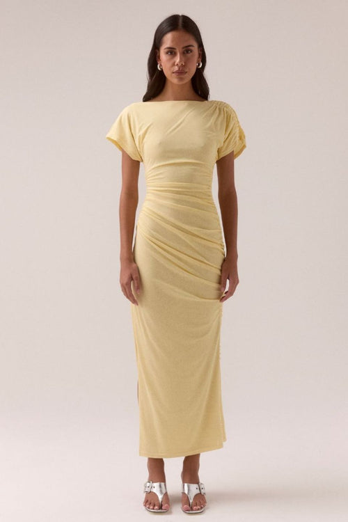 Lemon yellow maxi dress with short sleeves, ruched side detailing, high side slit, and a straight neckline, worn by a model in silver heels against a neutral background.
col_pattern