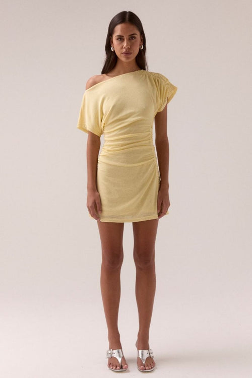 Lemon yellow off-shoulder mini dress with ruched side detailing, short draped sleeve, and fitted silhouette, worn by a model standing front-facing against a neutral background.