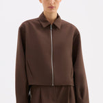 Person wearing a brown outfit on a white background