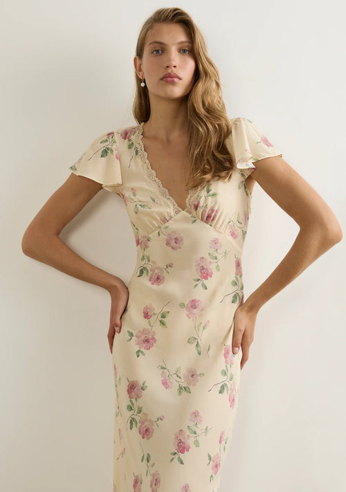 model wears a cream floral dress