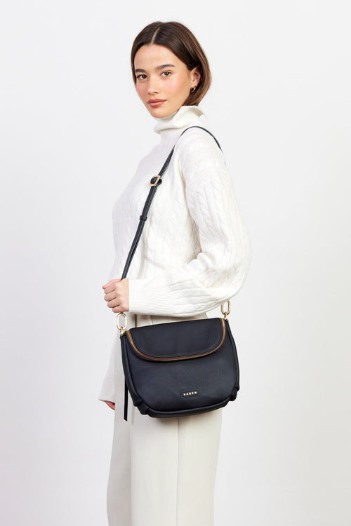 Woman holding a navy blue handbag against a white background
