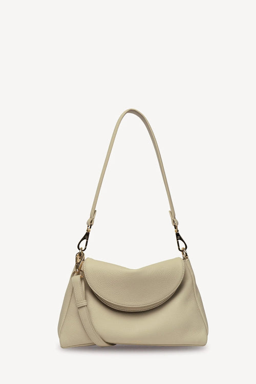 A light beige leather shoulder bag with a curved flap, a long shoulder strap, and a detachable crossbody strap, shown against a plain white background.