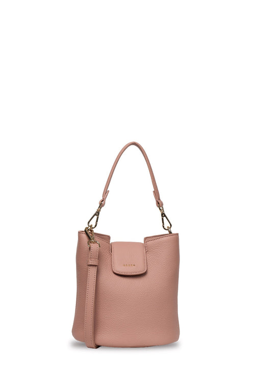 A dusty pink pebbled leather bucket bag with a top handle, a front flap pocket, and a detachable shoulder strap, shown against a plain off-white background.
