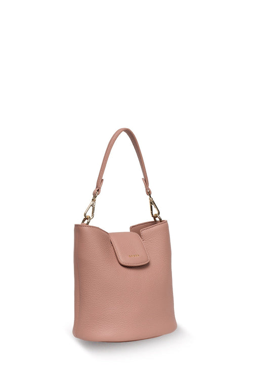 A dusty pink pebbled leather bucket bag with a top handle, gold-tone hardware, and a front flap detail, shown on a clean off-white background.