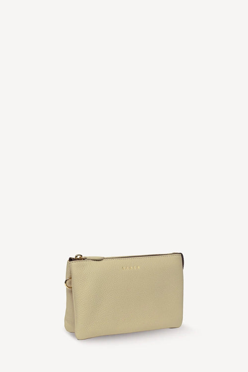A small beige pebbled leather pouch with a gold-tone zipper and a debossed logo on the front, photographed on a clean white background.