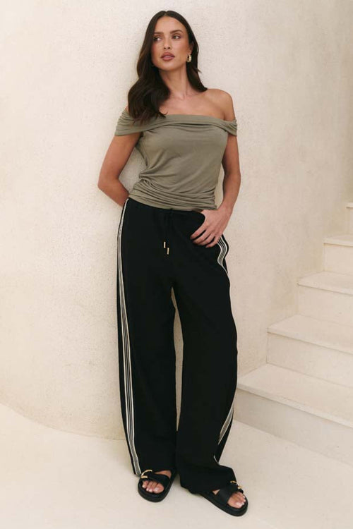 model wearing khaki ruched top and black pants