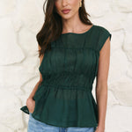 model wearing a green shirred top