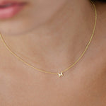 woman wearing gold necklace with initial