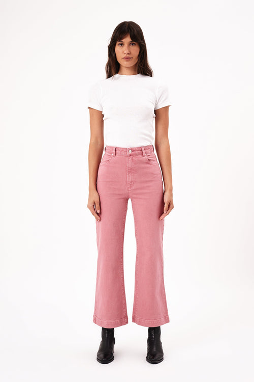 model wears pink jeans with a white tee shirt