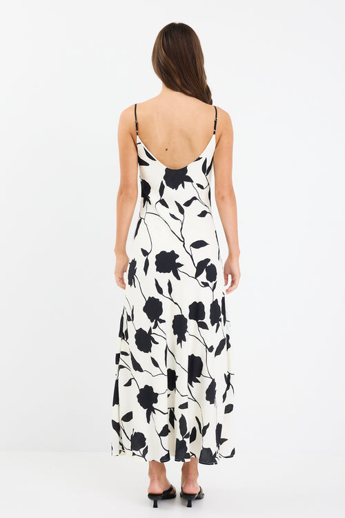 A strappy ivory dress with a bold black floral print, featuring a bias-cut design and fully lined interior. Made from 80% Viscose and 20% Nylon for a soft, breathable feel.