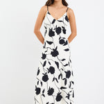 A strappy ivory dress with a bold black floral print, featuring a bias-cut design and fully lined interior. Made from 80% Viscose and 20% Nylon for a soft, breathable feel.