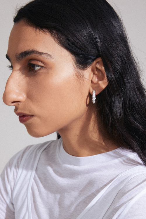 model wearing silver stud hoop earrings