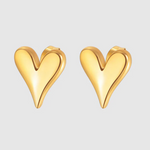 A pair of polished gold-toned heart-shaped stud earrings with a fluid, curved design and a slightly elongated point, giving a modern, sculptural look.