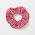 Large red and white gingham cotton scrunchie photographed on a white background.’