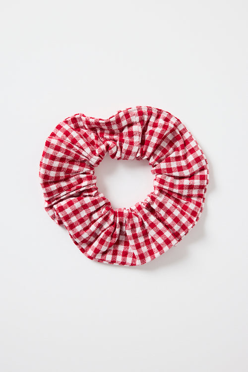 Large red and white gingham cotton scrunchie photographed on a white background.’