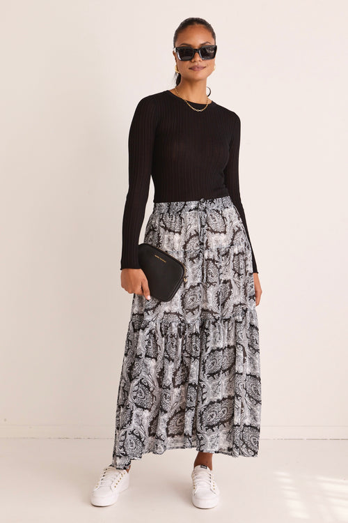 model wears a black print maxi skirt
