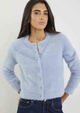Woman wearing a light blue cardigan against a white background