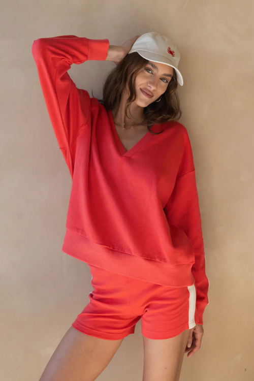 model wears red cotton knit sweater and red shorts