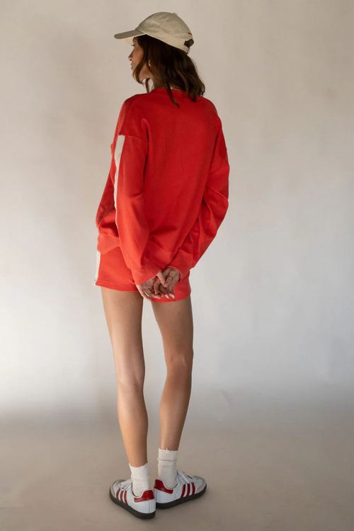 model wears red cotton knit sweater and red shorts