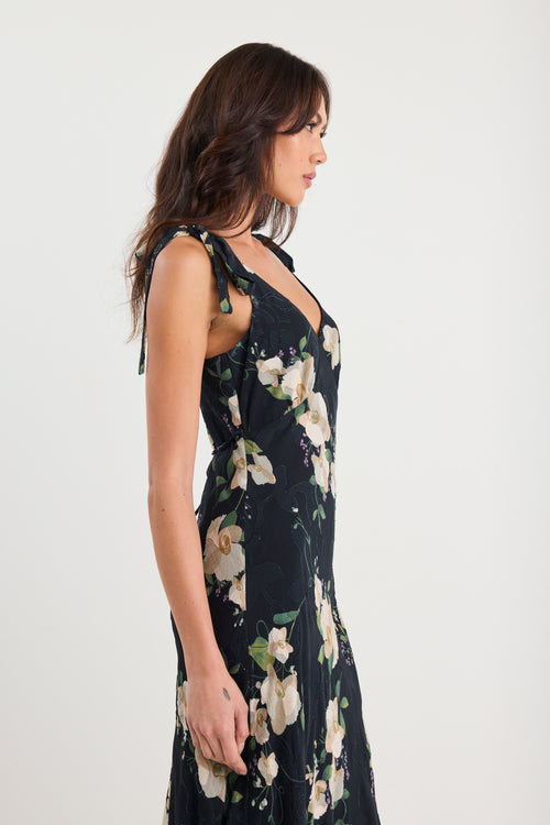 Woman wearing a black floral dress against a white background