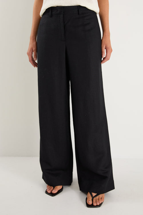 Black wide-leg pants worn by a person on a white background