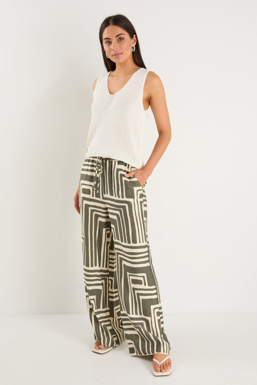 Woman wearing high-rise, wide-leg pants with an abstract khaki and ivory geo print and elasticated waistband with drawstring.