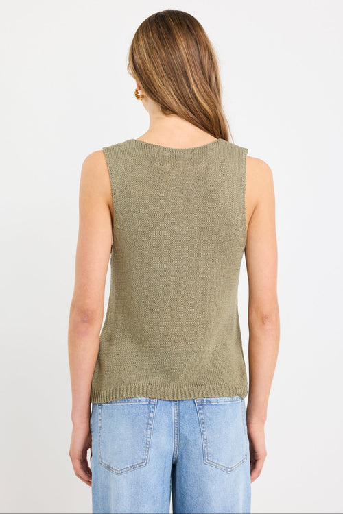 Woman wearing a sleeveless khaki knit top with a V neckline and relaxed fit, styled with light blue jeans.
col_pattern