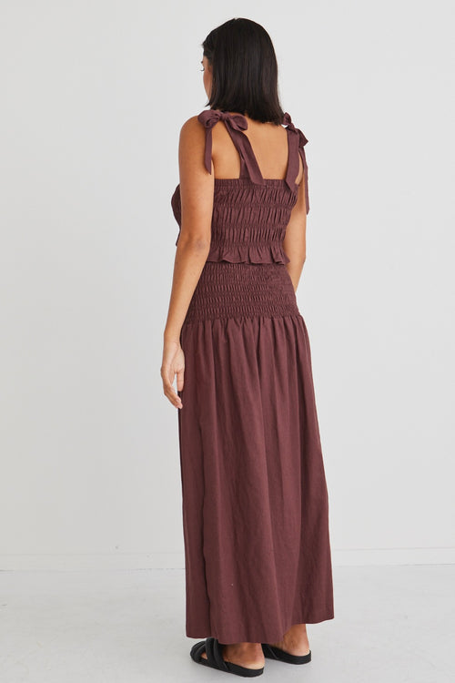 model posing in matching brown crop top and maxi skirt set
