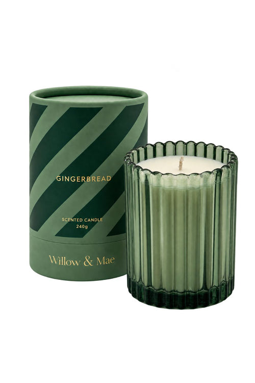 A green scented candle in a ribbed glass holder next to its matching green cylindrical packaging container with diagonal stripes. The brand 'Willow & Mae' is printed in gold on the base of the container.